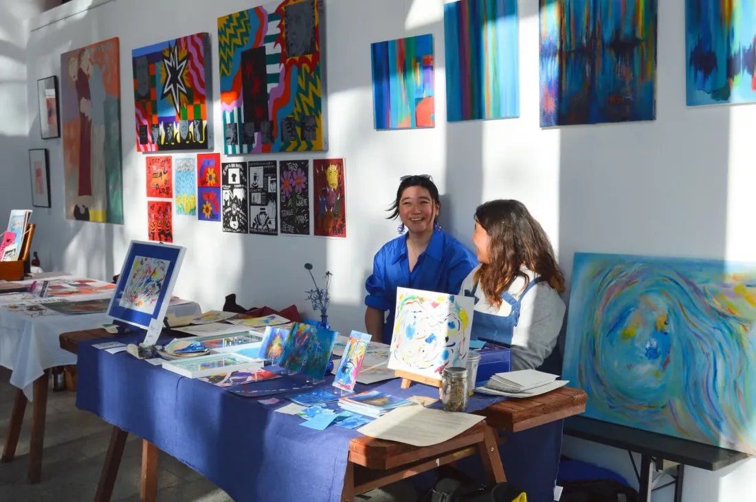 At an art-market stall with artist friend Lavia Lin, paintings and drawings on the wall