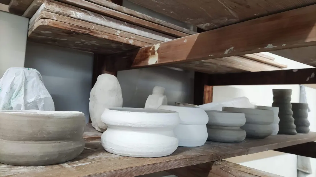 Greenware bowls drying on the studio shelves