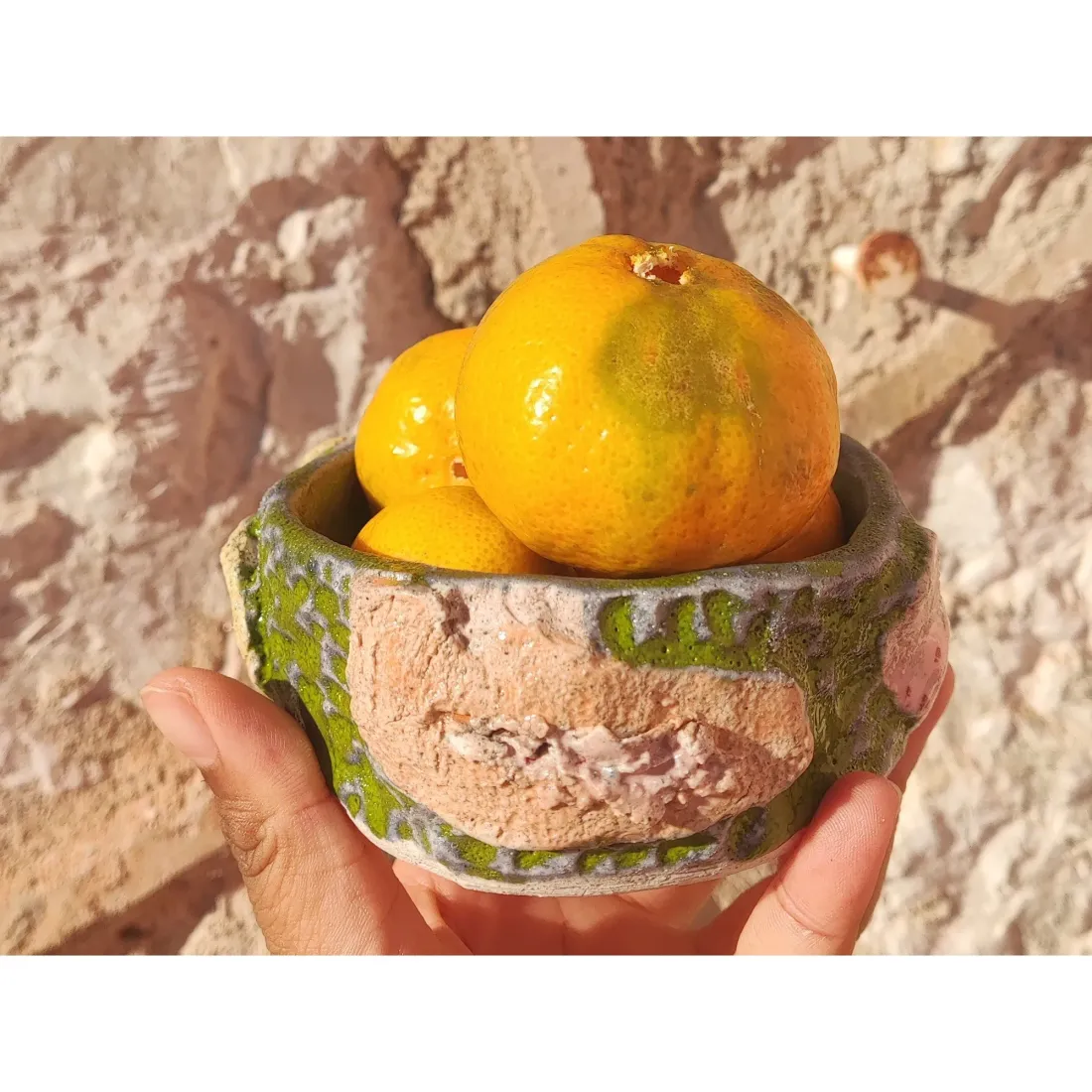 Green-and-orange cup against a terracotta wall