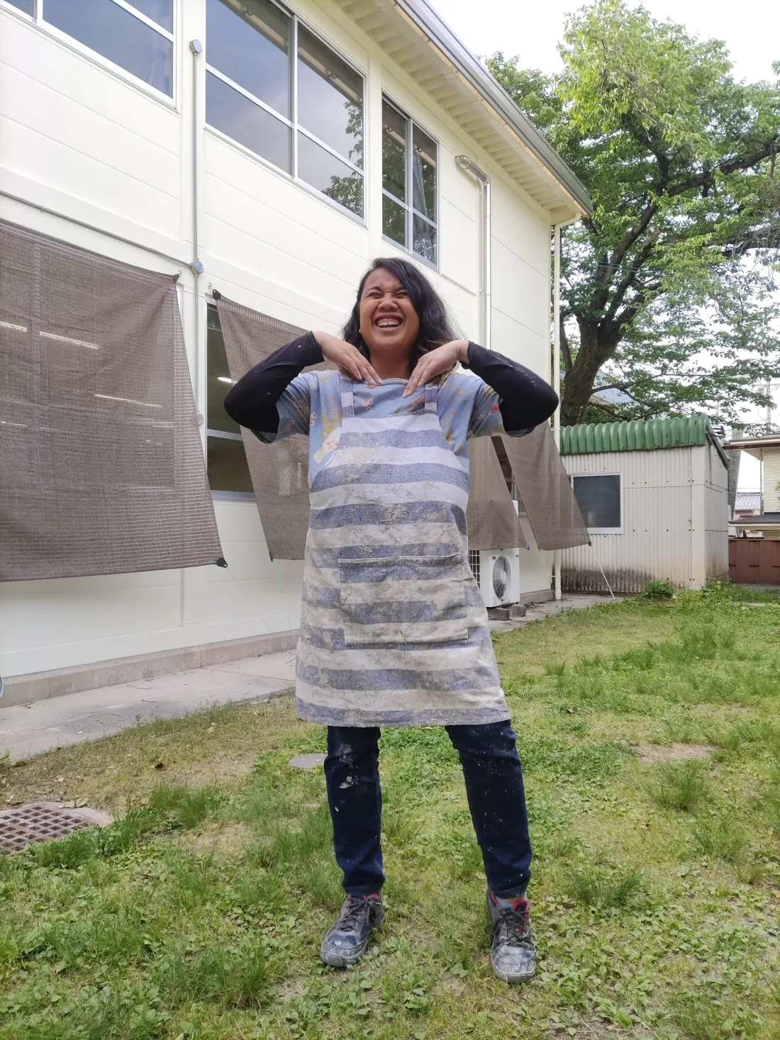 All smiles in a clay-covered studio apron