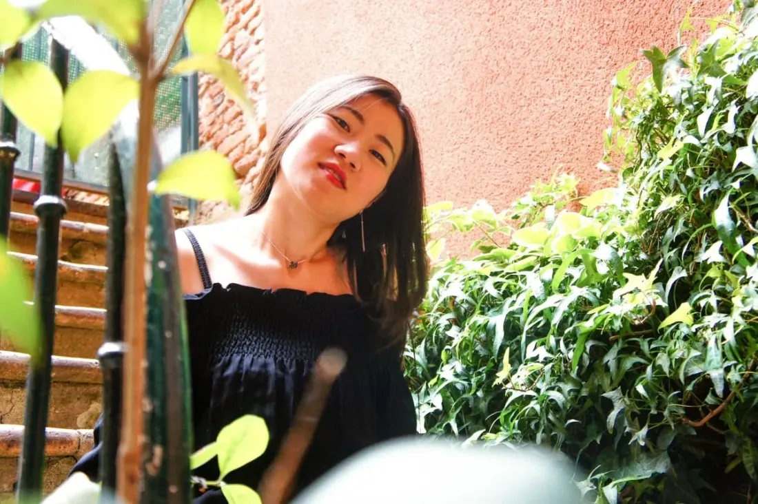 Portrait framed by leaves, against a warm ochre wall